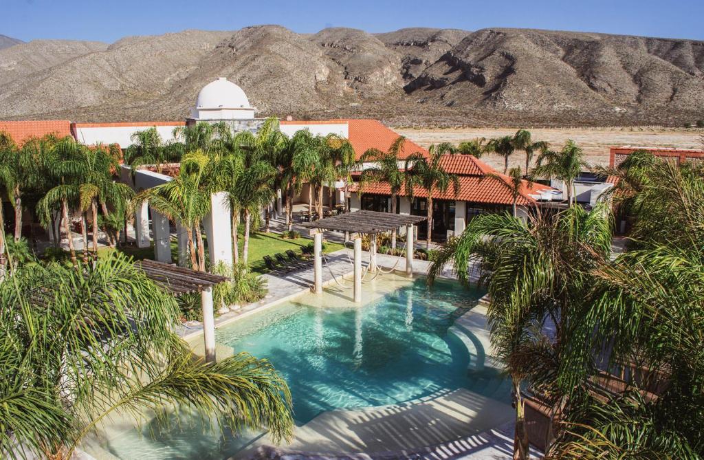 Cuatrociénegas de Carranza的住宿－Hacienda 1800，享有度假村的空中景致,设有棕榈树游泳池