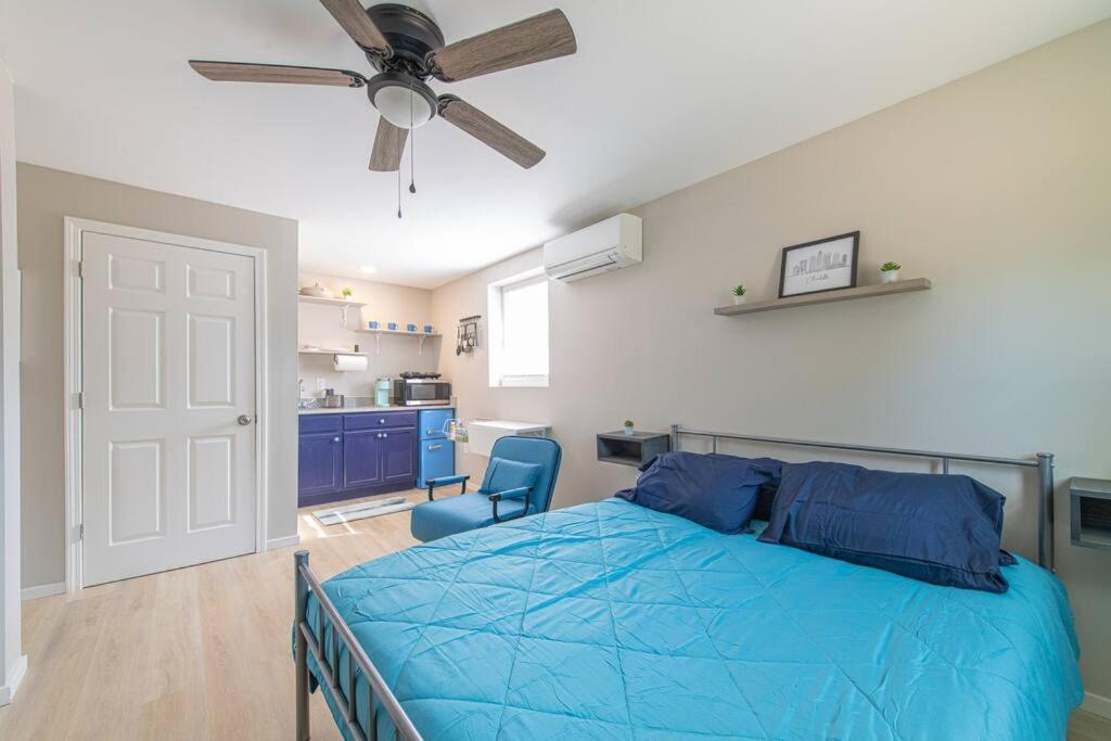 1 dormitorio con 1 cama azul y ventilador de techo en TheCozyCorner in Concord en Concord