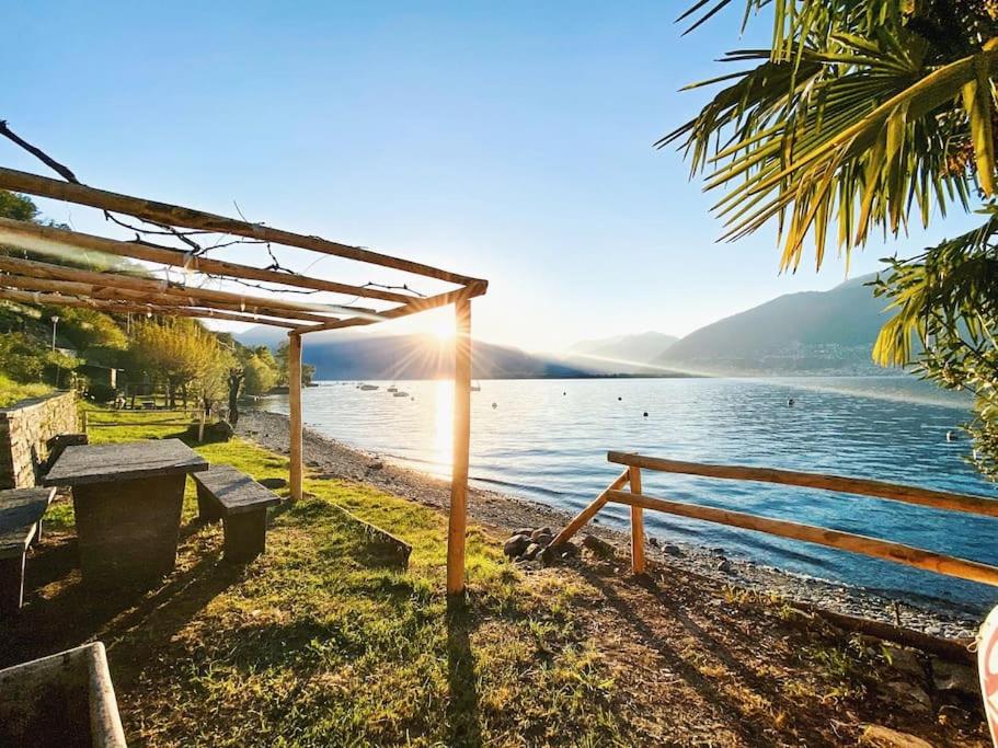 a picnic table and a bench next to a body of water at Boho Lake House - Private Beach 600m from the property - Free Parking - Home Cinema Room in Vira