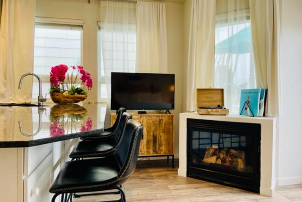 a living room with a fireplace and a television at Pier View Suites - Studio A in Cayucos