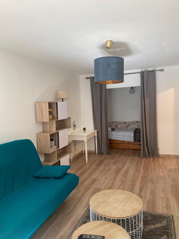 a living room with a blue couch and a bed at Le manège in Chambéry