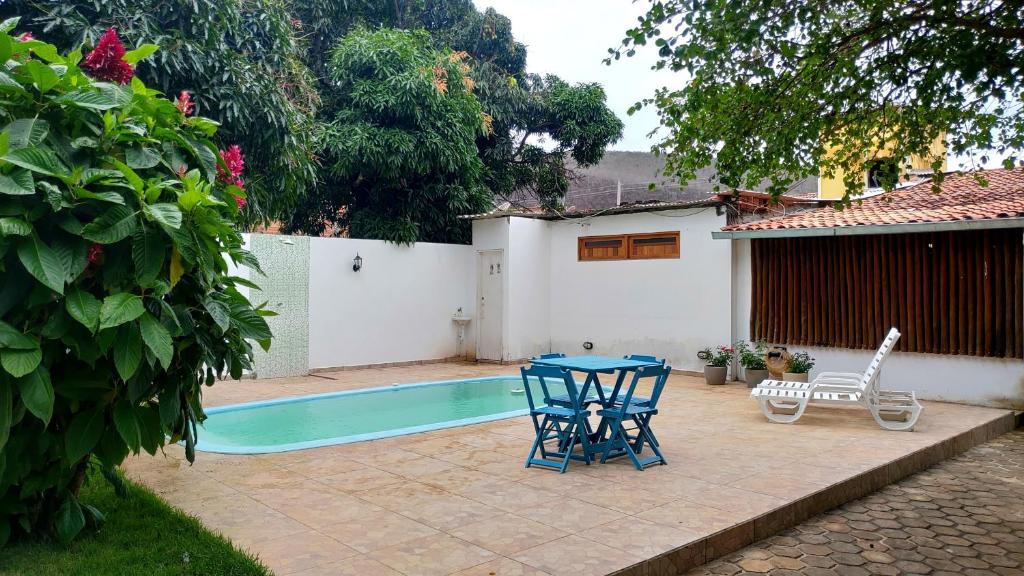 un patio con mesa y 2 sillas junto a una piscina en Pousada Caminhos da Chapada en Palmeiras