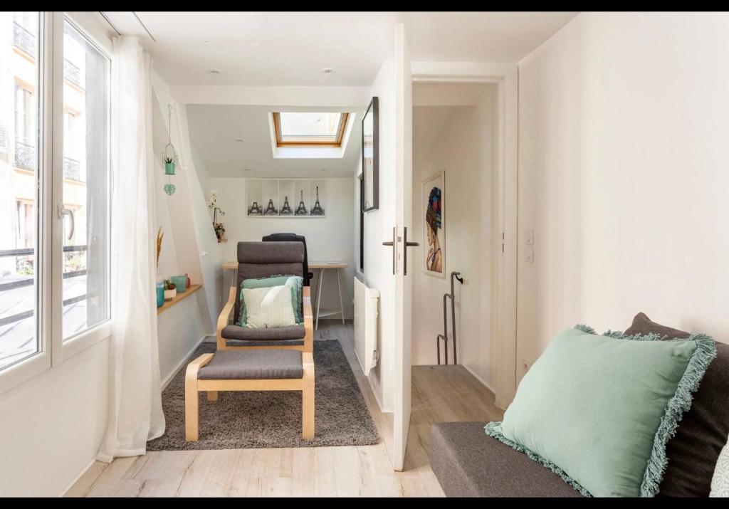 ein Wohnzimmer mit einem Stuhl und einem Tisch in der Unterkunft Home Jardin du Luxembourg à Paris in Paris