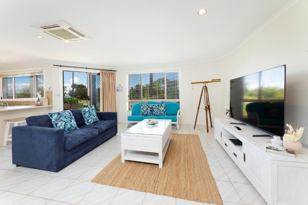 a living room with a blue couch and a tv at Coral Sands 2 in Forster