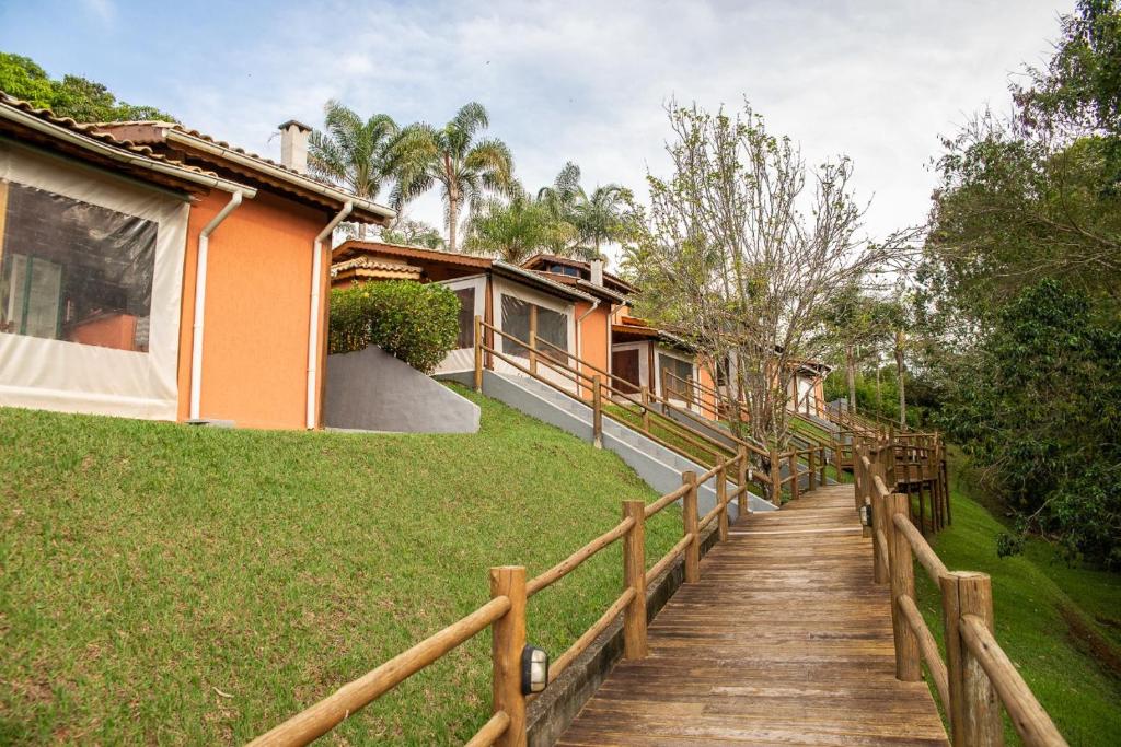 un camino de madera que conduce a una casa en Chalé das Águas en Igaratá