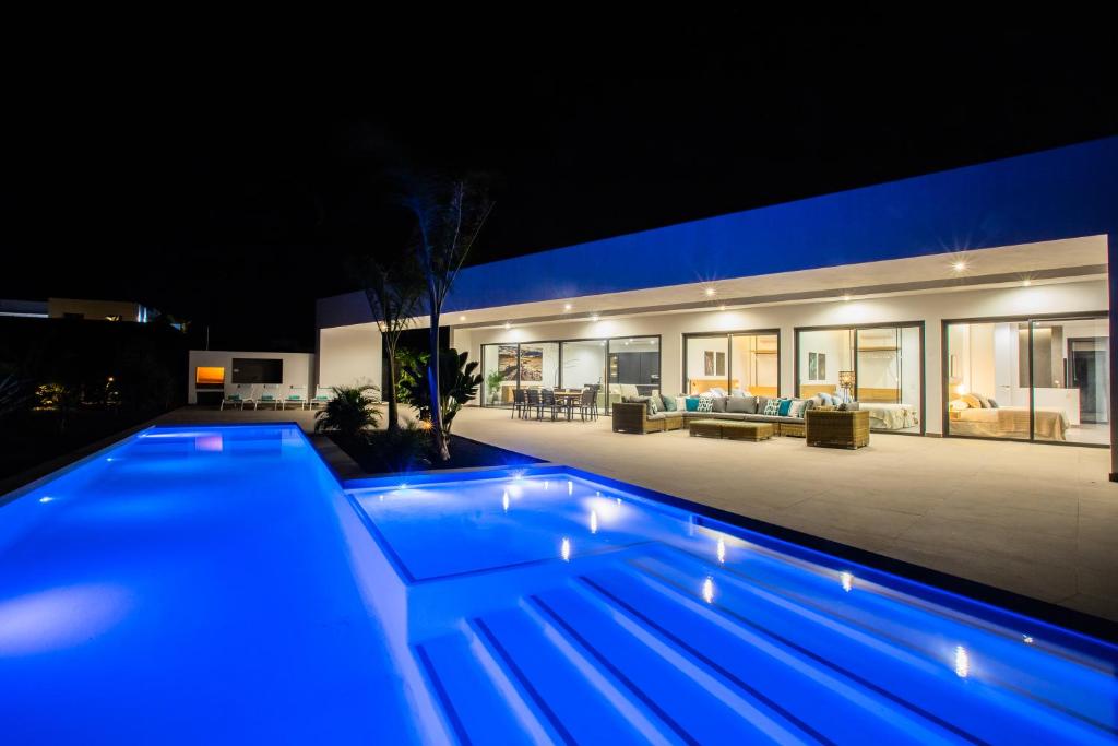a swimming pool in front of a house at night at Villa Macán in Teguise
