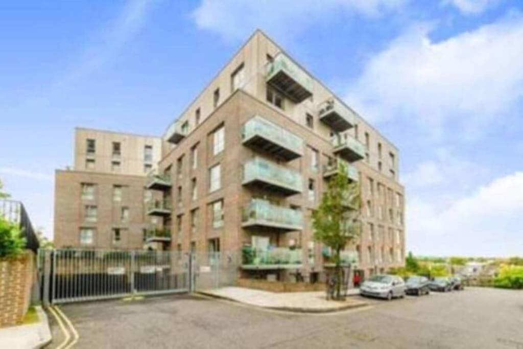 um edifício de apartamentos com carros estacionados num parque de estacionamento em Luxury 2 bedroom apartment in Central London with free Parking em Londres