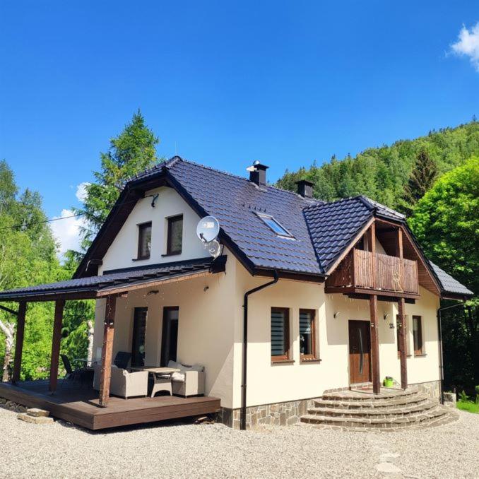 une petite maison blanche avec un toit dans l'établissement Dom nad rzeką, à Nowy Gierałtów