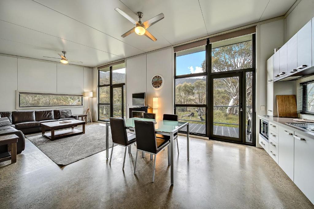 a kitchen and living room with a table and chairs at Ecocrackenback 5 in Crackenback