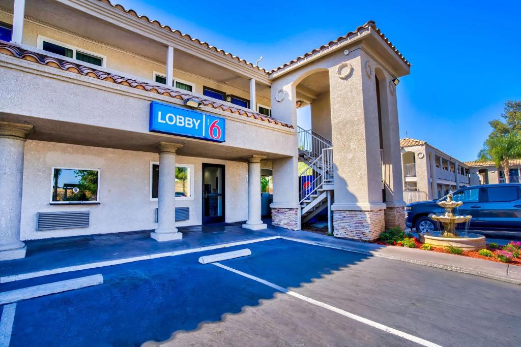 un hotel con un cartel en un estacionamiento en Motel 6-Menifee, CA, en Menifee