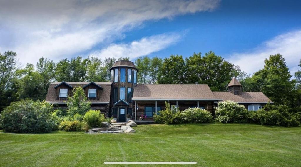 a house with a water tower on top of a yard at Hillside Estate - 14 Acre Waterfront Log home on Lake Champlain in Grand Isle
