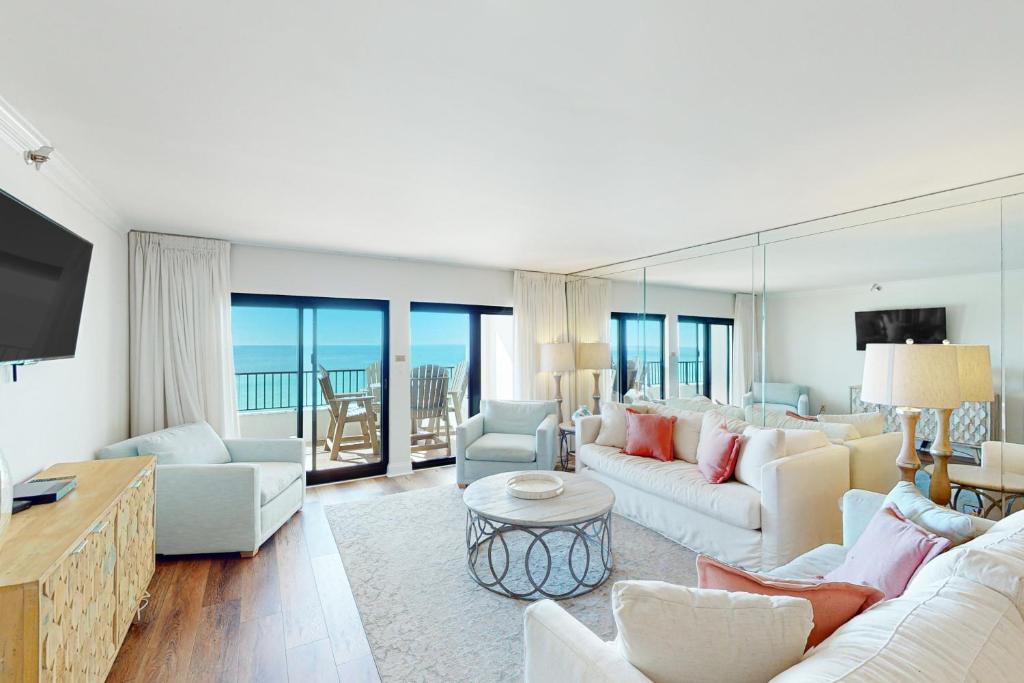 a living room with white furniture and a view of the ocean at Breakers East 604 in Destin