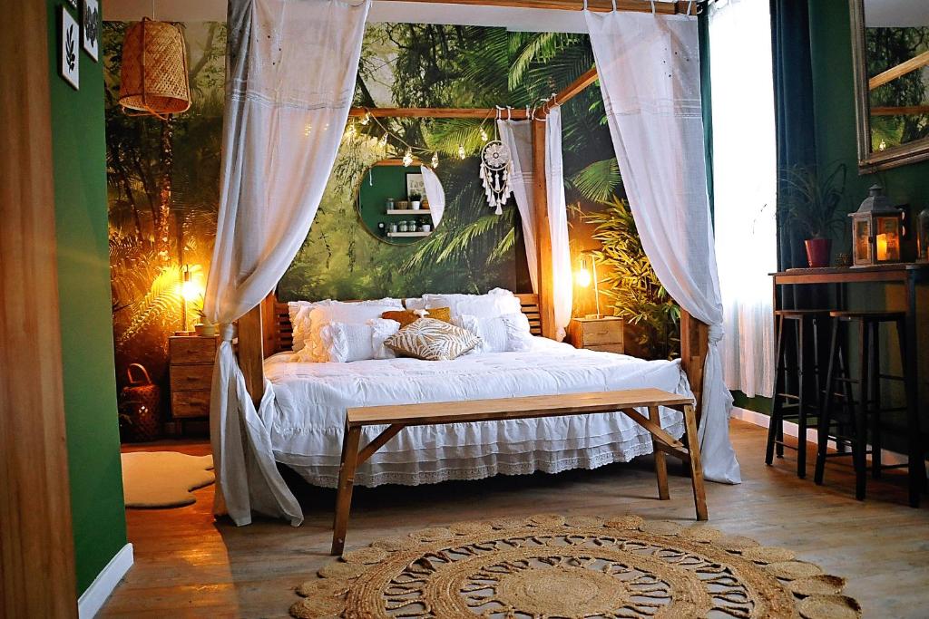 - une chambre avec un lit à baldaquin dans l'établissement L'évasion romantique au coeur de la jungle, à Évreux