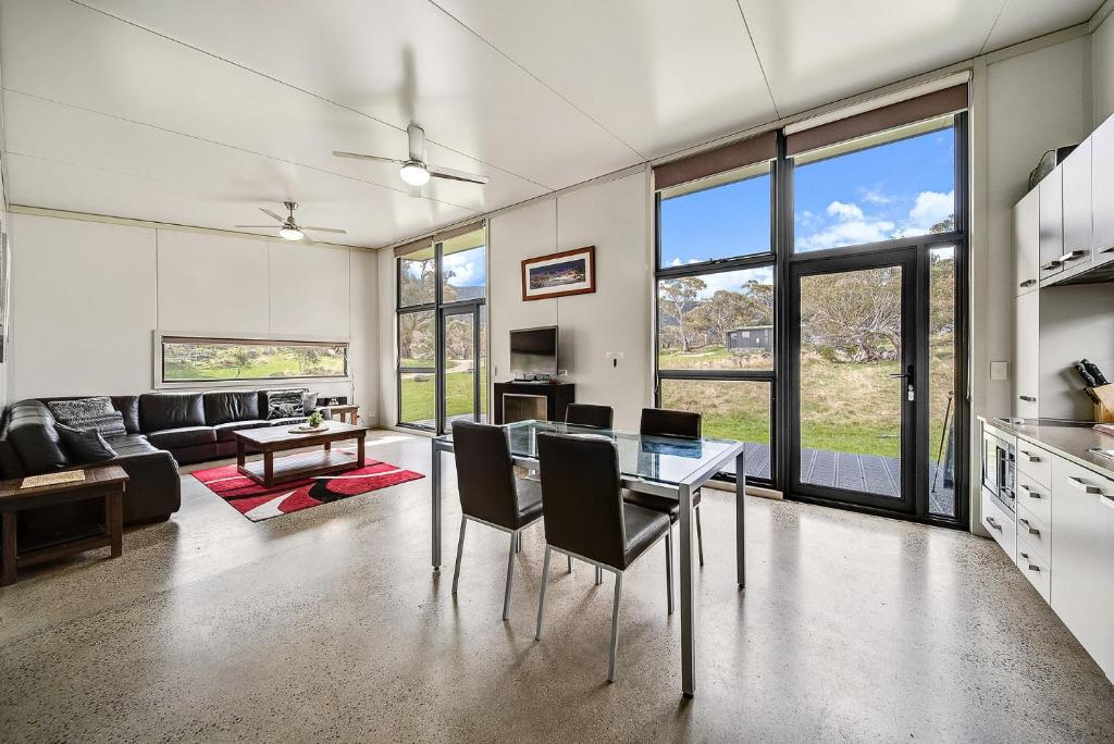 a kitchen and living room with a table and chairs at Ecocrackenback 16 Sustainable chalet close to the slopes in Crackenback