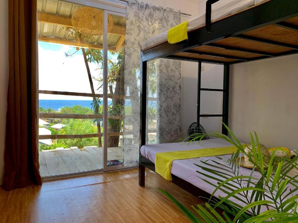 a bedroom with a bunk bed and a large window at Casita Lodge Kubo in San Juan