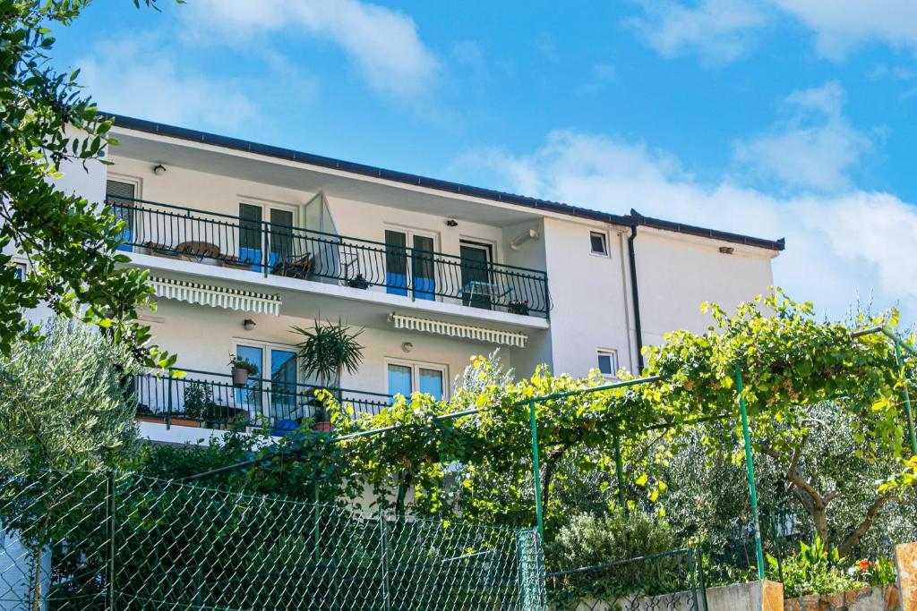 a white building with balconies and a fence at Apartments by the sea Gradac, Makarska - 20041 in Gradac