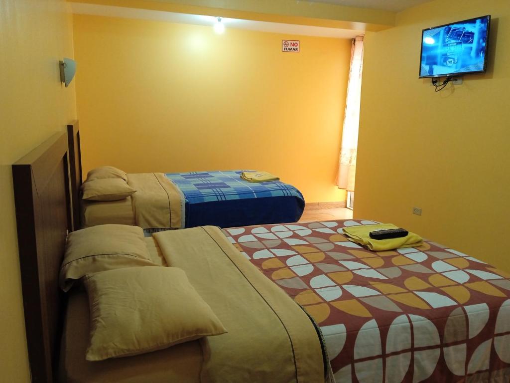 Habitación de hotel con 2 camas y TV en Hotel Residencial Miraflores, en Loja