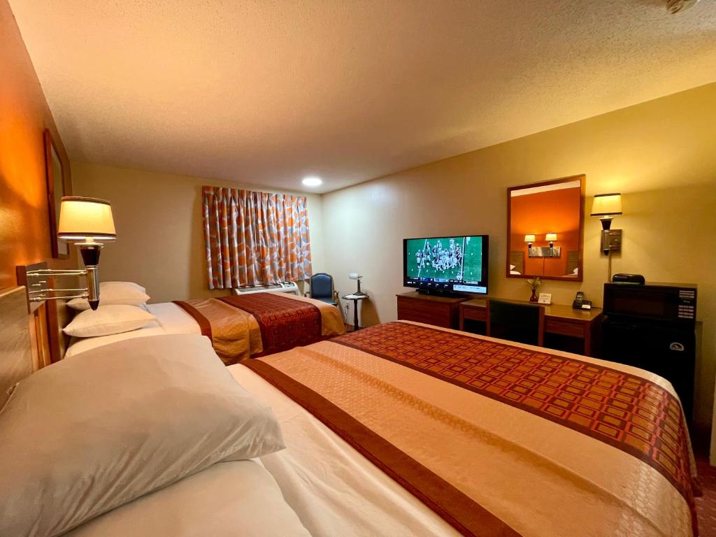 a hotel room with two beds and a flat screen tv at Sibley Inn in Sibley