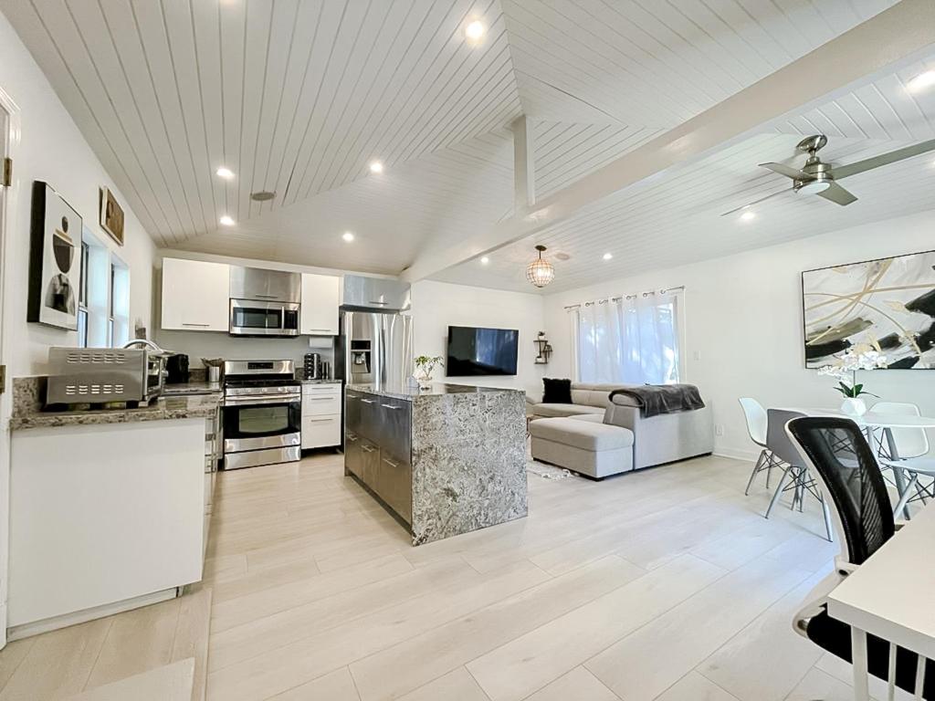 a large kitchen and living room with white appliances at Pristine 1BD/1BA Bungalow + Hot Tub - Ocean Park in Los Angeles