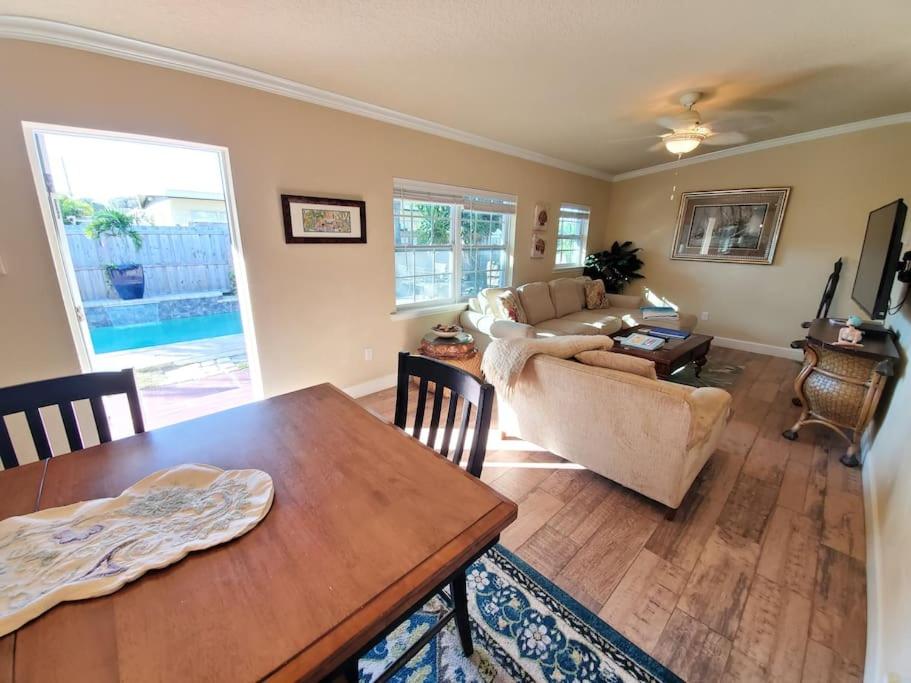 a living room with a table and a couch at Bahamian Cottage - Heated Pool Walk to the Beach in Cocoa Beach