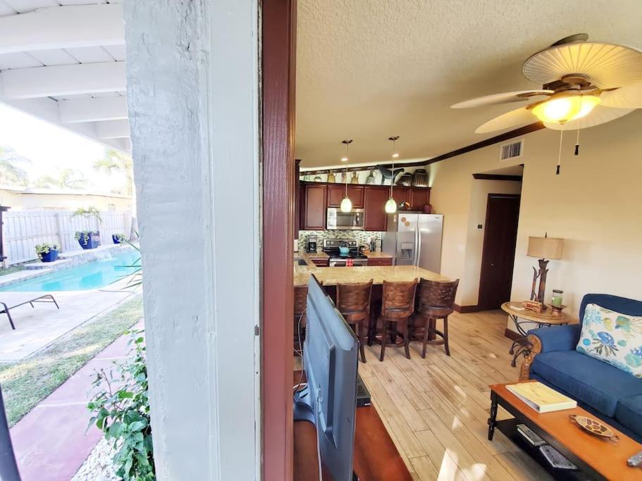 ein Wohnzimmer mit einem blauen Sofa und einer Küche in der Unterkunft Hawaiian Cottage - Heated Pool Walk to the Beach in Cocoa Beach