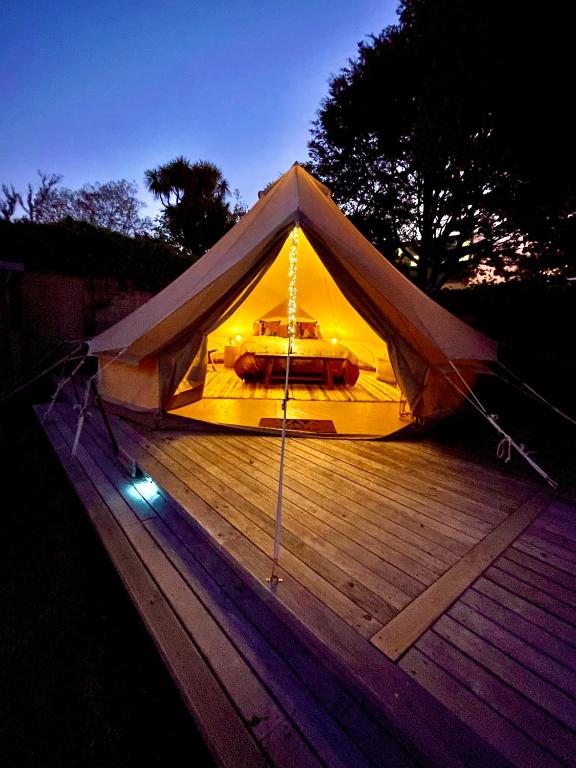 a yellow tent on a wooden deck at night at Te Anau Lakefront Backpackers in Te Anau