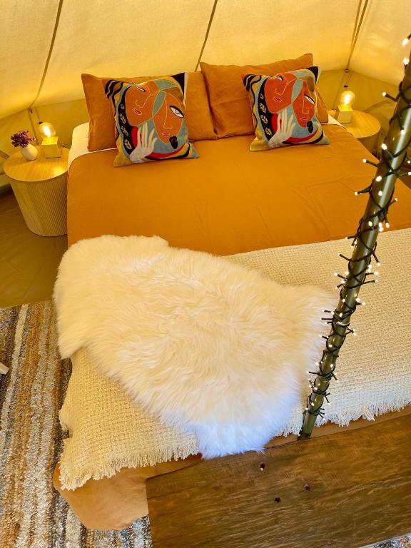 a white furry rug on a bed in a tent at Te Anau Lakefront Backpackers in Te Anau
