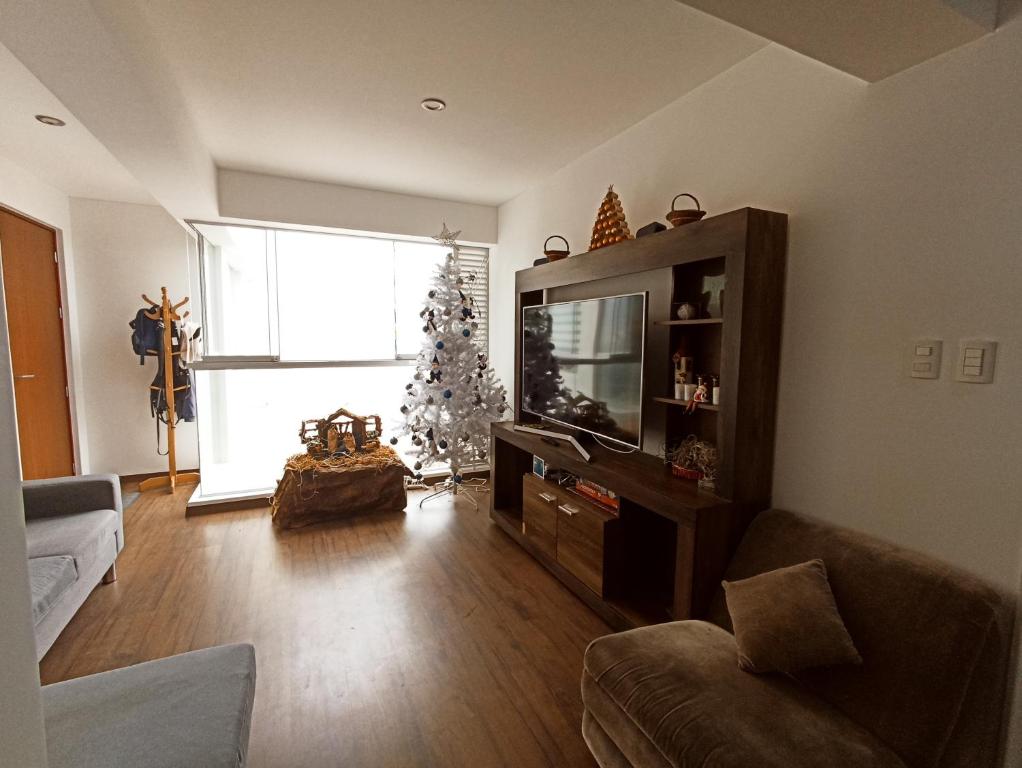 una sala de estar con un árbol de Navidad en la ventana en MWhite'sHome, en Lima