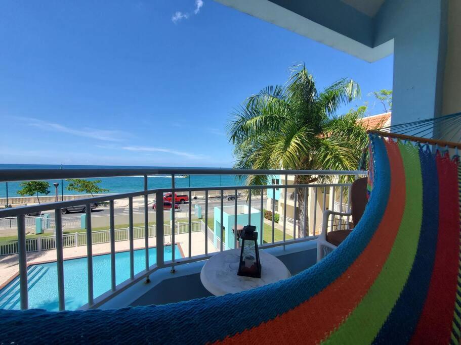 a balcony with a hammock and a view of the ocean at Summer all year! Oceanfront with Pool A/C in Aguadilla