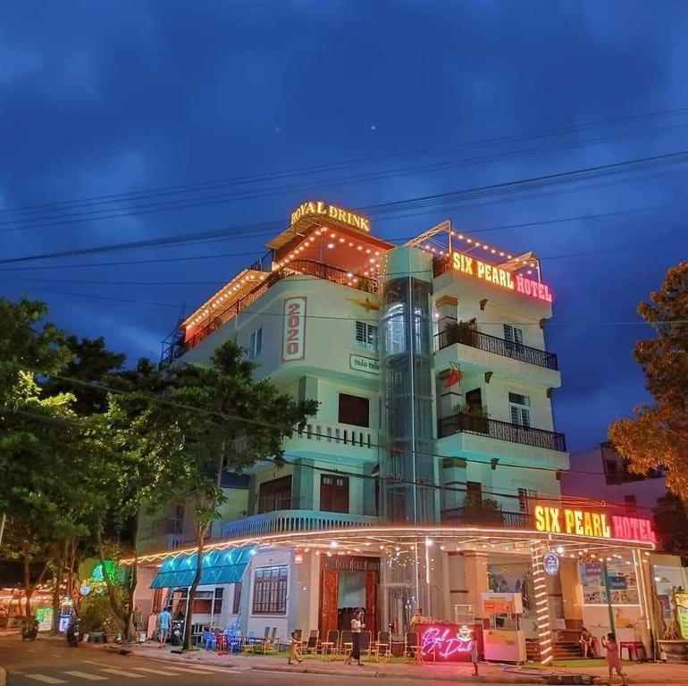 un edificio con insegne al neon sopra di esso di SixPearl Hotel a Con Dao
