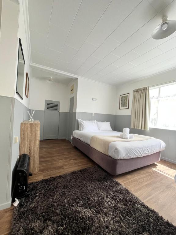 sypialnia z dużym łóżkiem i dywanem w obiekcie Bings Motel w mieście Blenheim