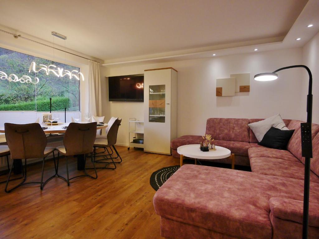 a living room with a couch and a table at Upland Apartments - Fewo Zeitgeist (inkl. MeineCardPlus) in Willingen