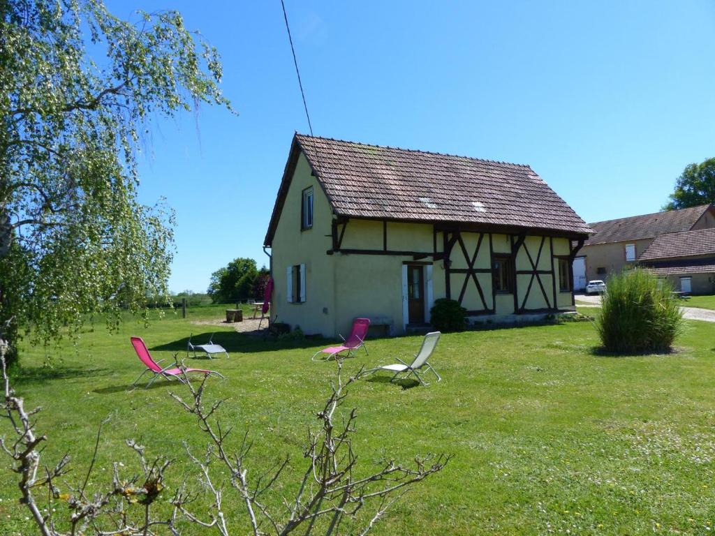 ein Haus mit zwei Stühlen im Gras davor in der Unterkunft Gîte Diou, 4 pièces, 7 personnes - FR-1-489-12 in Diou