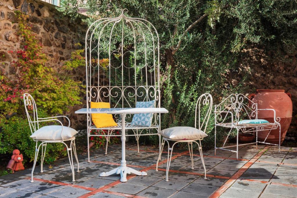 eine Gruppe von Stühlen und einem Tisch in einem Garten in der Unterkunft Palazzo Badiale history&rooms in Atella