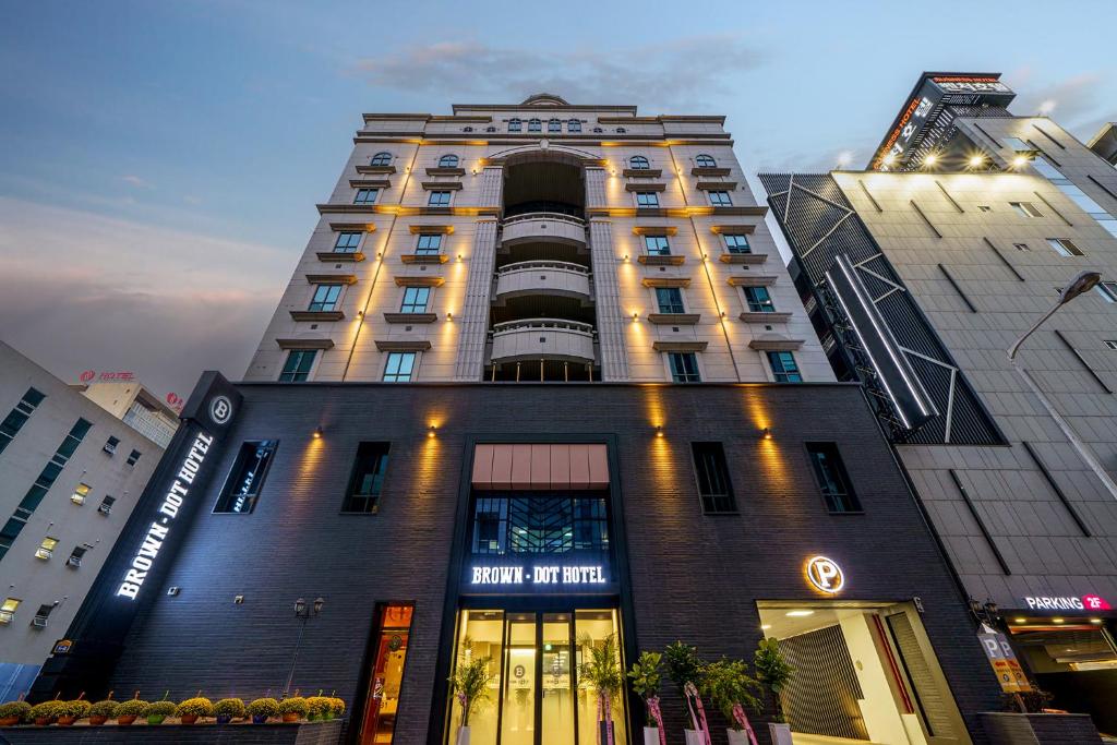 a tall building with a sign on it at Browndot Hotel Sangmu in Gwangju