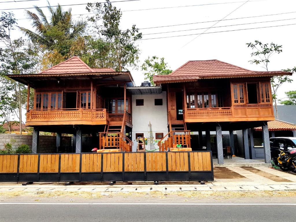 une maison avec 2 balcons sur le côté de la rue dans l'établissement Degolan Wooden House, à Ngemplak