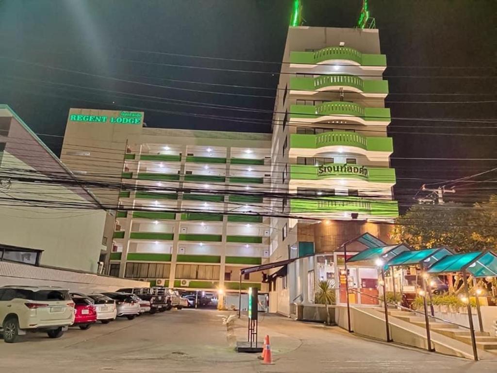 a parking lot in front of a building at night at Regent Lodge Lampang in Lampang