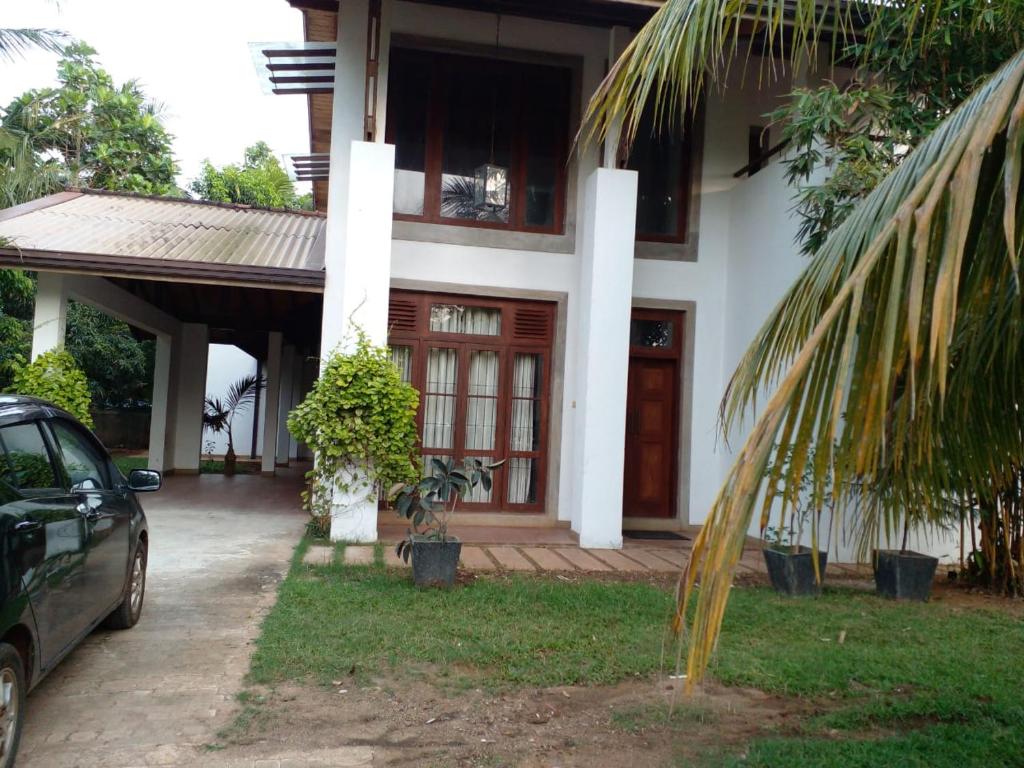 a house with a palm tree in front of it at Enola Holiday Resort in Anuradhapura
