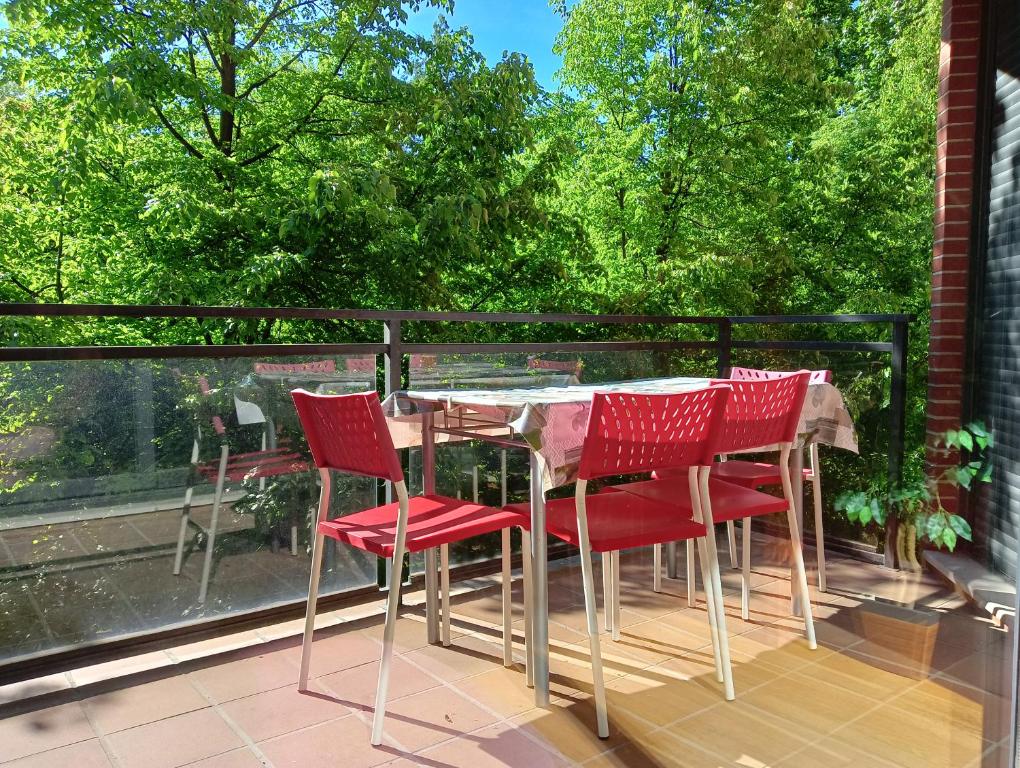 una mesa y sillas en un balcón con árboles en La Terraza de Zahara, en Pamplona