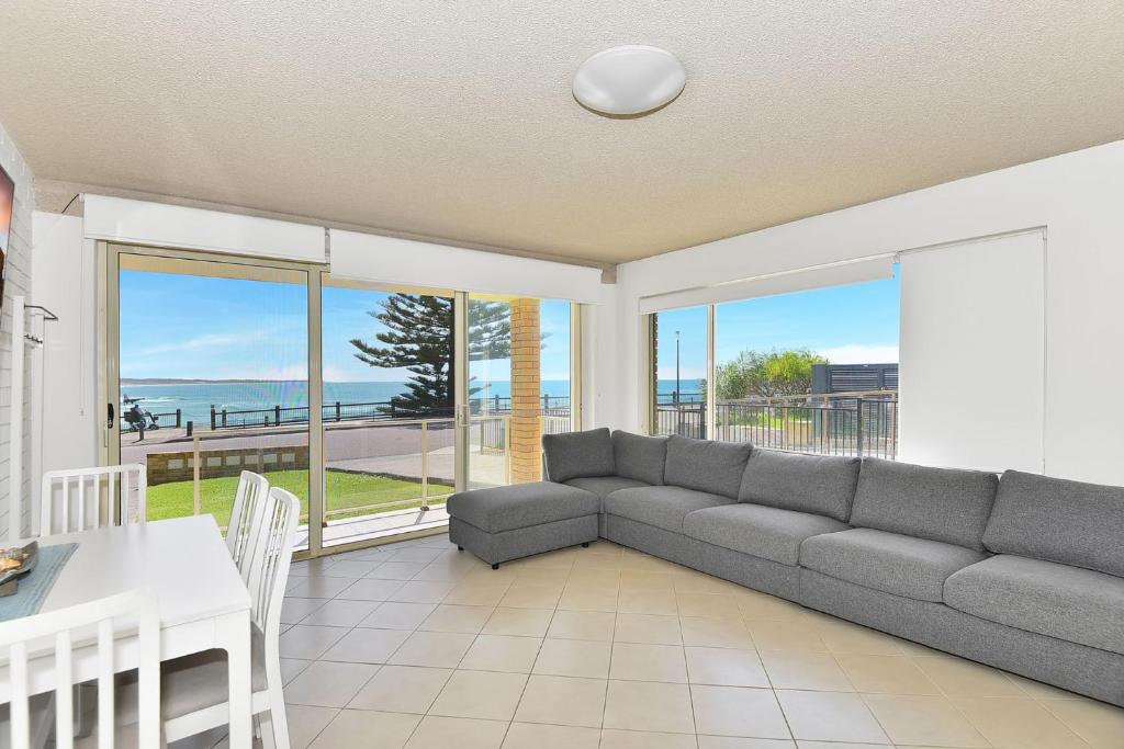 una sala de estar con un sofá y una mesa en Waterviews on Marine Apartment 1, en The Entrance