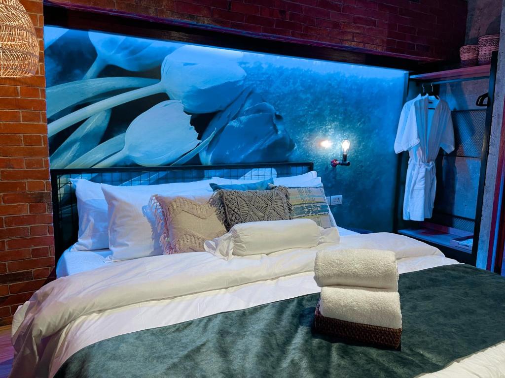 sypialnia z dużym łóżkiem z obrazem na ścianie w obiekcie Blue Tulip w mieście Pusok