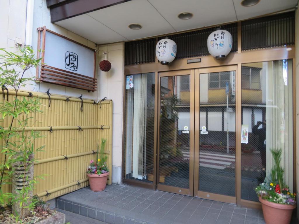 un ingresso a un edificio con porte e piante in vetro di Miharaya Ryokan a Gujo