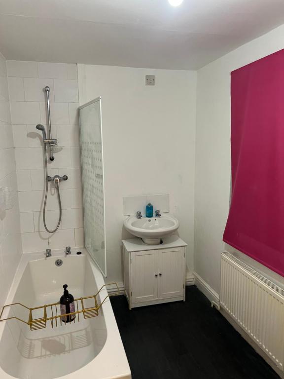 a bathroom with a bath tub and a sink at Superb Lime Guest House in Shildon