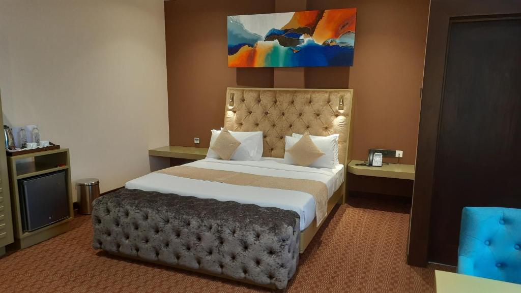a hotel room with a large bed with a large headboard at Viluxey City Hotel in Maharagama