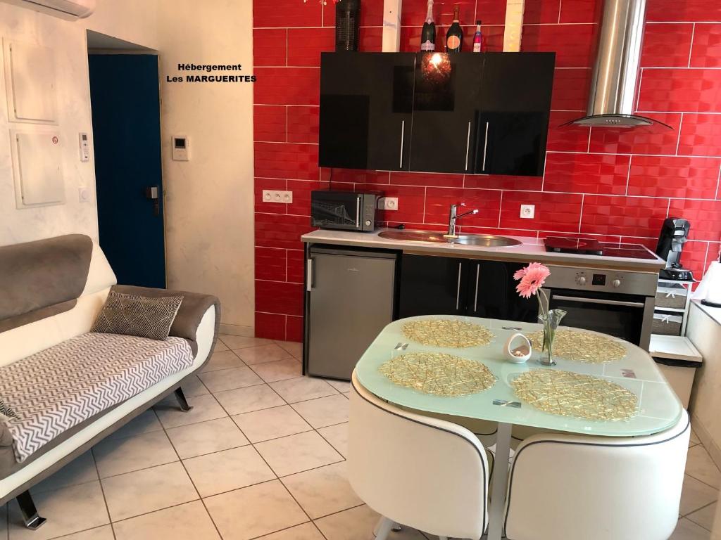 a kitchen with a table and a sink and a table at La Petalerie in Épernay