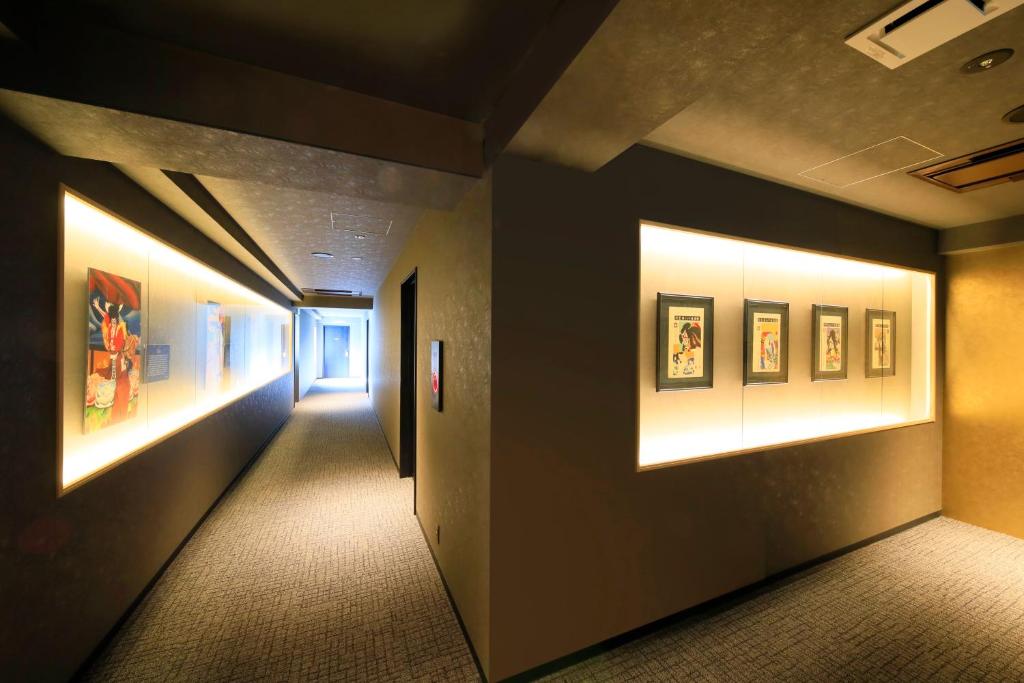 a hallway in a building with paintings on the walls at Waqoo Naritasanmonzen in Narita