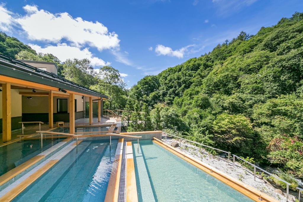 een zwembad met uitzicht op een berg bij Tateshina Grand Hotel Takinoyu in Chino
