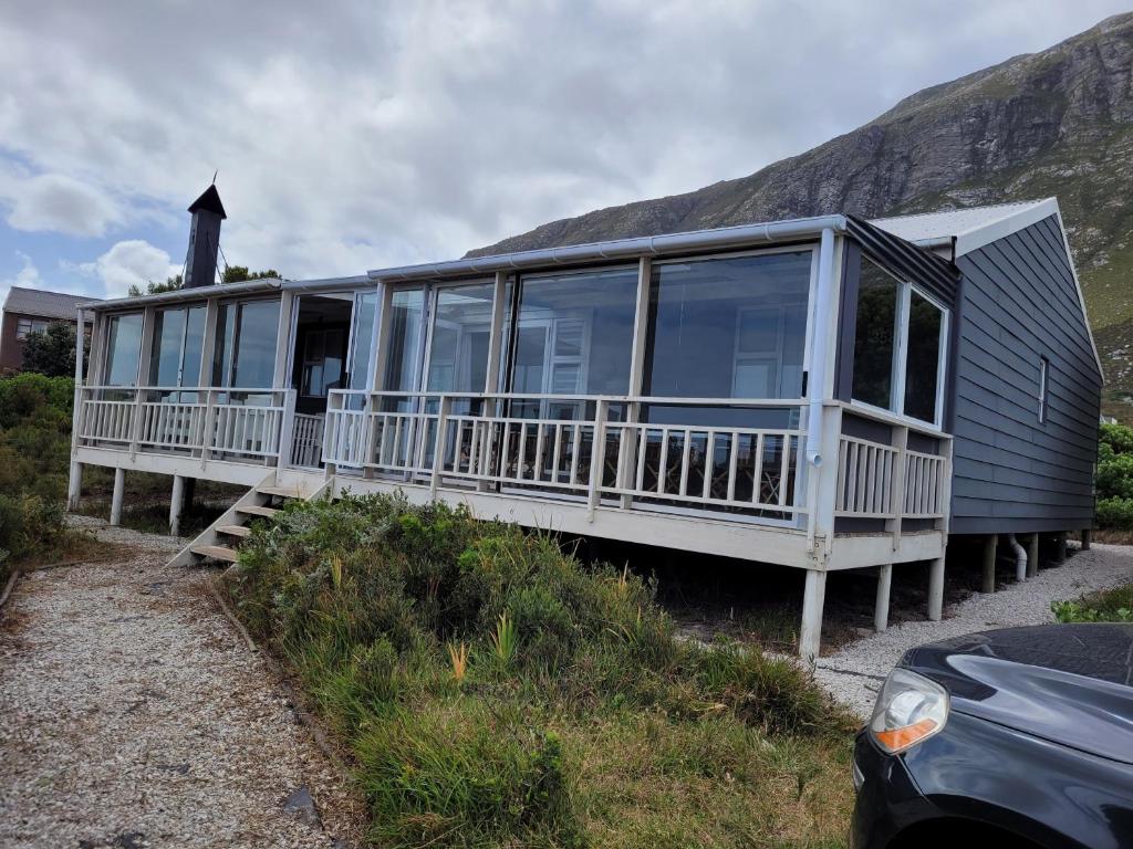 ein Haus mit einer großen Terrasse an der Seite in der Unterkunft Cottage Amnesia in Bettyʼs Bay