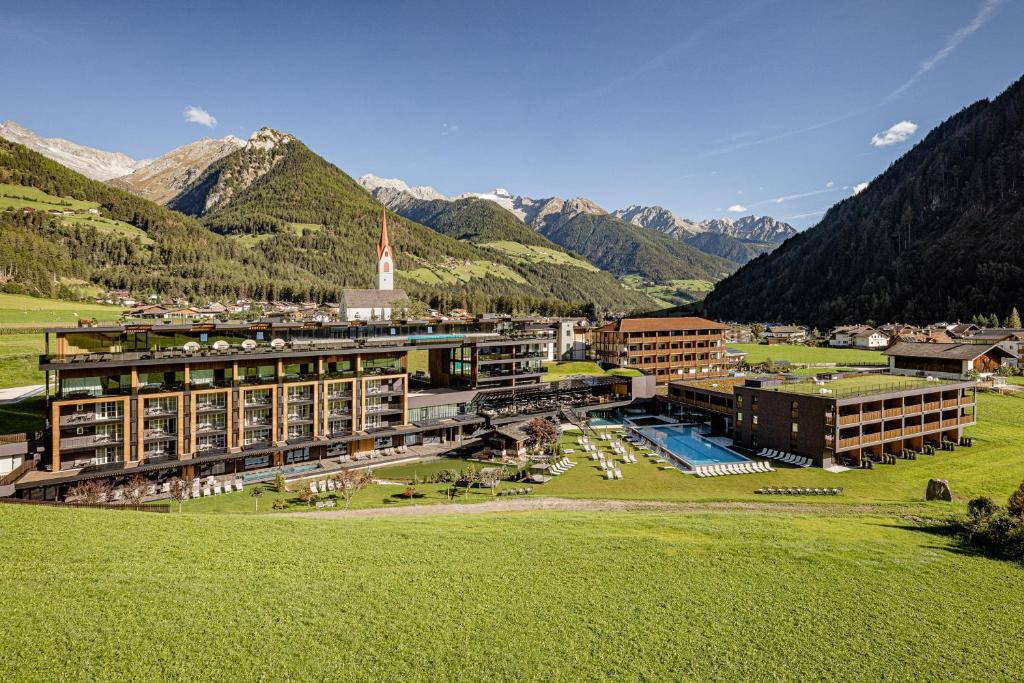 eine Luftansicht eines Resorts mit Bergen im Hintergrund in der Unterkunft Alpine Luxury SPA Resort Schwarzenstein in Luttach