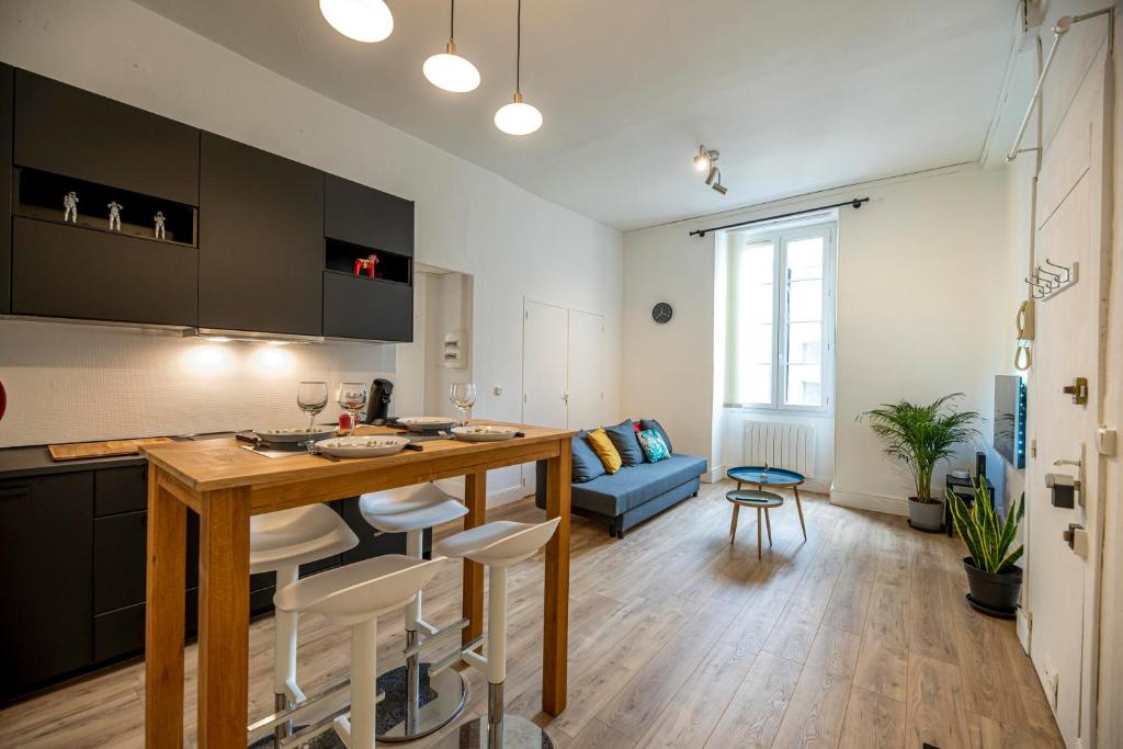 une cuisine et un salon avec une table et des chaises dans l'établissement Coeur de ville, magnifique appartement + parking, à Pau